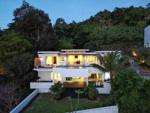 a house on the hill with the lights on at Cozy 5BR Villa Stunning SeaViews in Kamala Beach