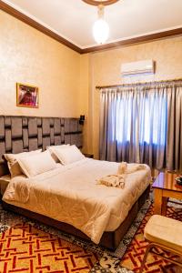 廷吉爾的住宿－HOTEL LA VALLEE DES KASBAHS CHEZ ILYAS，一间卧室设有一张大床和一个窗户。