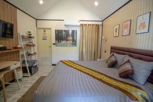 a bedroom with a large bed and a desk at ฟินอินดอย in Chom Thong