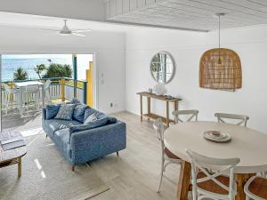 Paradise Palms Tangalooma في تنجالوما: غرفة معيشة مع أريكة زرقاء وطاولة