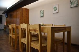uma sala de jantar com uma mesa de madeira e cadeiras em CEJITAS HOSTEL em Córdoba