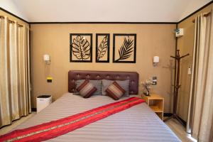 a bedroom with a large bed with three pictures on the wall at ฟินอินดอย in Chom Thong