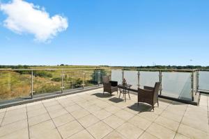 a patio with chairs and a table on a balcony at Heathrow Haven: Stylish Apartments in the Heart of Slough in Slough