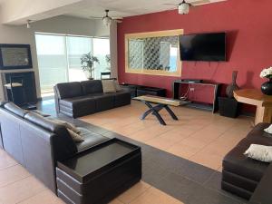 a living room with a couch and a flat screen tv at Hermoso Departamento frente al Mar in Tijuana