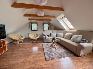 a living room with a couch and two chairs at Roubenka U Javoru in Desná