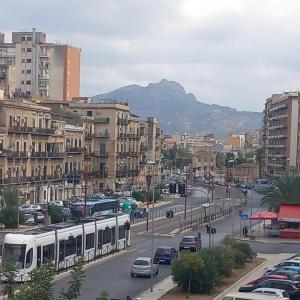 a city with a street with cars and a bus at AA Central Station Historical center in Palermo