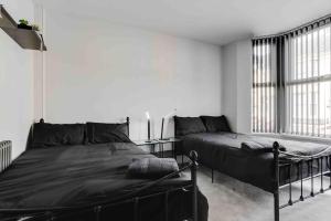 利物浦的住宿－4 bedroom stylish home central location，一间卧室设有两张床和大窗户