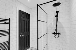 a bathroom with a black door and a glass shower at 4 bedroom stylish home central location in Liverpool