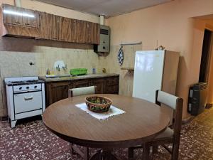 a kitchen with a wooden table and a refrigerator at La Casona de la tía in La Consulta