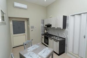 a kitchen with a sink and a stove top oven at Casetta del Granatello in Portici