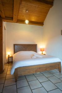 um quarto com uma cama grande e um tecto de madeira em Lou Rey Éco Hameau - Gîte, Chambre d'Hôtes & Table d'Hôtes em Le Collet-de-Dèze