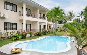 una villa con piscina di fronte a un edificio di Creole Breeze Self Catering Apartments a Mahe