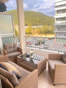 balcón con sofás, mesa y vistas en Άνετο διαμέρισμα - Κέντρο Ξάνθης, en Xanthi