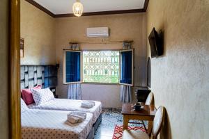廷吉爾的住宿－HOTEL LA VALLEE DES KASBAHS CHEZ ILYAS，客房设有床、沙发和窗户。