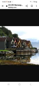 a screenshot of a website with houses on a dock at Nedre Amla Fjord Apartment in Kaupanger