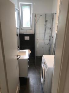 łazienka z umywalką i pralką w obiekcie Ferienwohnung am Schölerberg w mieście Osnabrück
