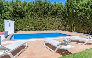 una piscina con 2 tumbonas y una piscina en Awesome Home In Ronda With 3 Bedrooms, Wifi And Outdoor Swimming Pool, en Ronda