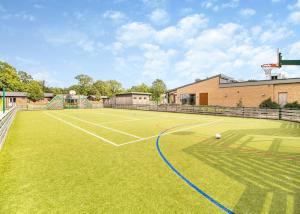 a tennis court with a tennis ball on it at Norfolk Woods Resort And Spa in Narborough