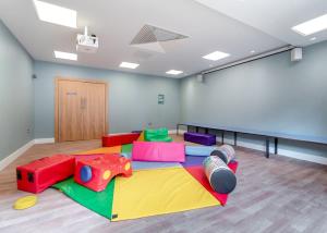 a room with colorful play equipment on the floor at Norfolk Woods Resort And Spa in Narborough