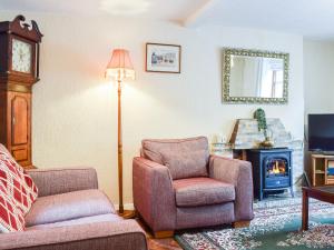 sala de estar con sofá, silla y chimenea en Sheldon House, en Braunston