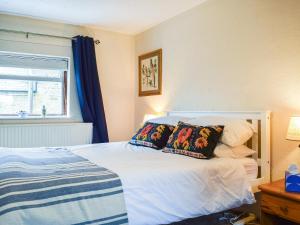1 dormitorio con cama con almohadas y ventana en Sheldon House en Braunston