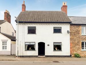 a white house with a black door and windows at Sheldon House in Braunston