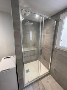 a shower with a glass door in a bathroom at Spacieux Studio pour toute la famille in Palavas-les-Flots