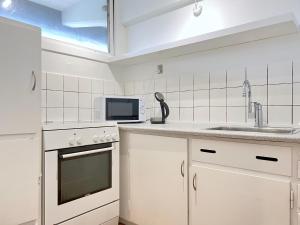 een witte keuken met een wastafel en een magnetron bij One Bedroom Apartment In Rdovre, Trnvej 41b, in Rødovre