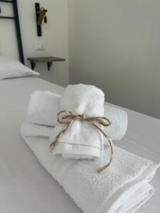 einen Stapel Handtücher, gefesselt mit einem Bogen auf einem Bett in der Unterkunft Dimora Dante in Amantea