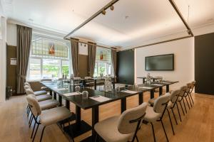 a conference room with a long table and chairs at Hotel Astoria in De Haan