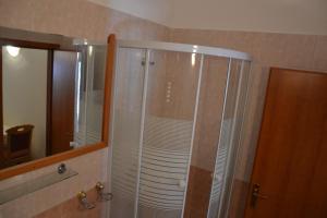 y baño con ducha y puerta de cristal. en Apartmani Dub, en Cavtat