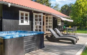 a house with a hot tub on a wooden deck at Stunning Home In Rdby With Wifi in Rødby