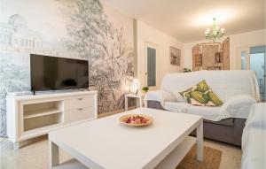 een woonkamer met een tv en een bank bij Awesome Apartment In Carmona With Wifi And 2 Bedrooms in Carmona