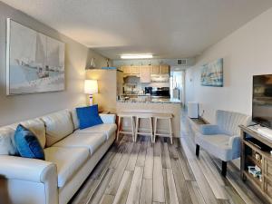 uma sala de estar com um sofá e uma cozinha em Villas Capri #2 em Fort Walton Beach