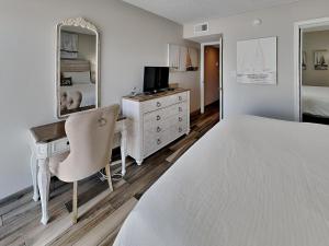 um quarto com uma cama e uma secretária com um computador em Villas Capri #2 em Fort Walton Beach