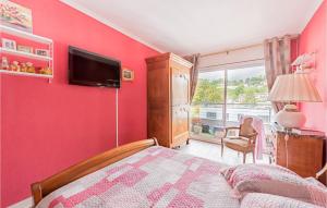 1 dormitorio con pared roja y TV de pantalla plana en 2 Bedroom Nice Apartment In Chaville, en Chaville