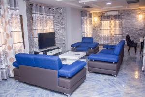 a waiting room with blue chairs and a flat screen tv at Grand appartement lomé centre ville mer clim 6pers in Lomé