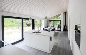 Glesborgにある3 Bedroom Amazing Home In Glesborgの白いキャビネットと大きな窓付きのキッチン