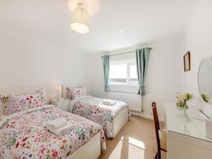a bedroom with two beds and a desk and a mirror at Hillcroft in Alnwick