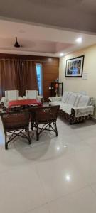 Sala de estar con 2 camas y mesa en Hotel Shiva Krishna(Unit of Nandan Udyam Pvt Ltd), en Patna