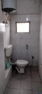 a small bathroom with a toilet and a window at Hotel Shiva Krishna(Unit of Nandan Udyam Pvt Ltd) in Patna