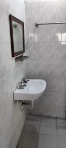 baño con lavabo y espejo en la pared en Hotel Shiva Krishna(Unit of Nandan Udyam Pvt Ltd), en Patna