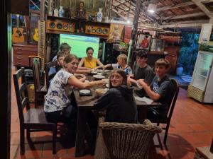 a group of people sitting at a table in a restaurant at Charming Countryside Homestay in Ben Tre