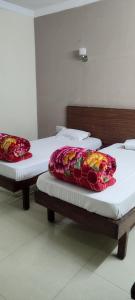 two twin beds in a room with white sheets at Hotel Shiva Krishna(Unit of Nandan Udyam Pvt Ltd) in Patna