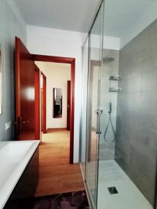 een badkamer met een glazen douche en een hal bij casanita in Abano Terme