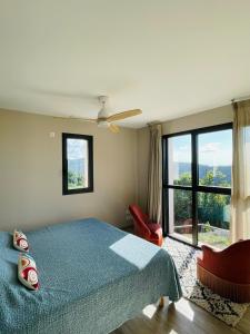 a bedroom with a bed and a large window at Les Vignals in Arphy