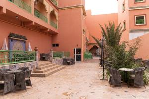 a courtyard of a building with chairs and tables at HOTEL LA VALLEE DES KASBAHS CHEZ ILYAS in Tinerhir