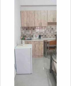 a kitchen with a white refrigerator and a table at Margaret home 