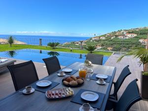 una mesa con comida y vistas al océano en Villa Livramento, en Ponta do Sol