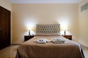 a bedroom with a bed with two slippers on it at Carlos Paz Departamentos in Villa Carlos Paz +22 photos